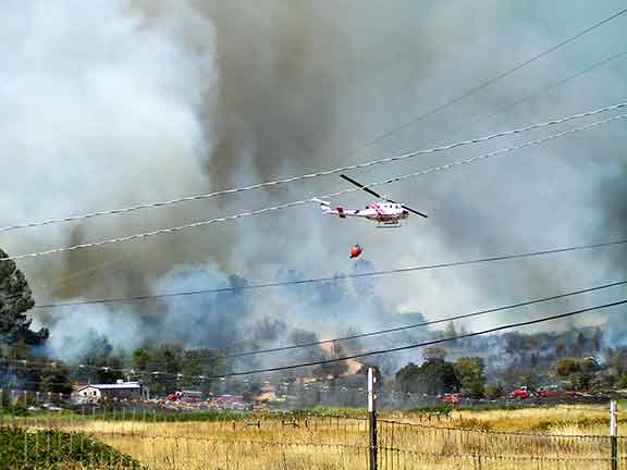 Image of the fire crew and helicopter dropping water.